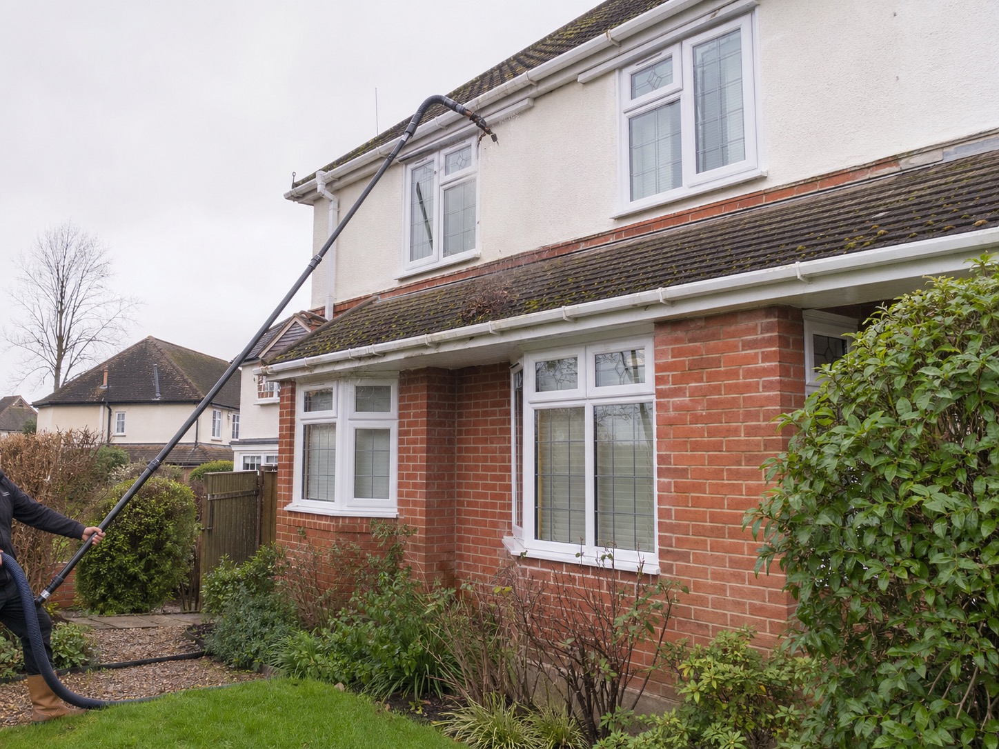 Gutter vacuum pole cleaning a roofline in Mid Sussex